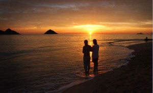 Una pareja contempla el atardecer en una playa de Kailua, Hawai.